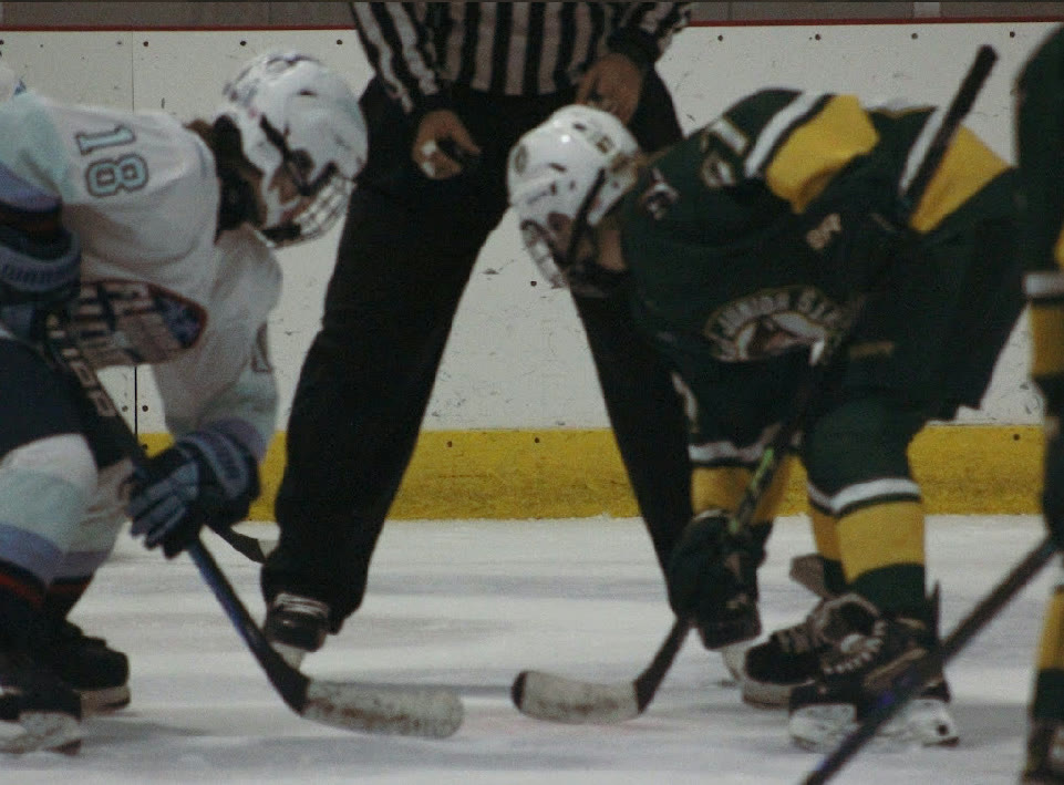 Low at the dot with hands set on the stick and a square stance, opponent mirrored across from her